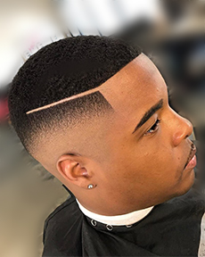 teenage african american customer at Bladez Barber shop in Fort Worth with black spray on edge up